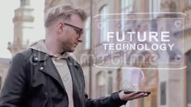 戴眼镜的聪明年轻人展示了未来技术的概念全息图