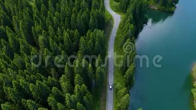 从飞机上可以看到汽车行驶在前方和湖边。 美丽的山路。 在山路上开车.. 道路