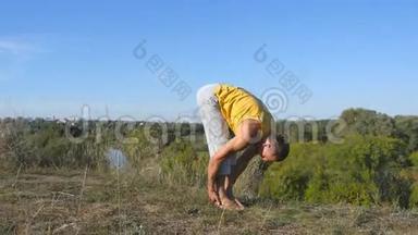 在户外练习<strong>瑜伽</strong>动作和姿势的人。 年轻<strong>男子</strong>站在<strong>瑜伽</strong>姿势的自然。 做体力活的运动员