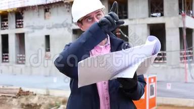 施工工程师或建筑师戴安全帽，在施工现场有施工方案..