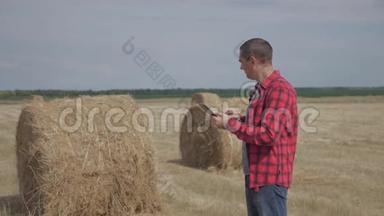 智慧生活方式<strong>农耕</strong>农业理念.. 一名农民工人在数字平板电脑上的田野里研究干草堆。 慢慢
