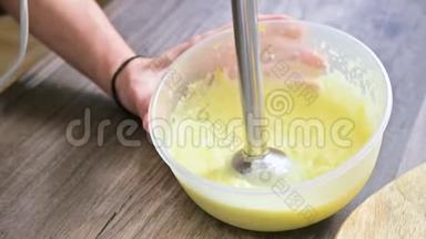 将自制蛋黄酱用搅拌机在塑料碗中搅拌