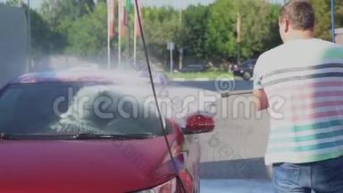 年轻的白种人正在洗车自助服务。 洗车。