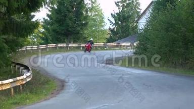 一个骑摩托车的人。 年轻的帅哥骑摩托车在山路上。