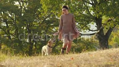 可爱的小女孩和她可爱的狗在日落时一起跑步
