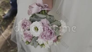 新娘穿着<strong>蕾丝连衣裙</strong>，捧着美丽的白色婚礼花束。