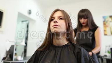 理发店的一位年轻女士被女理发师理发
