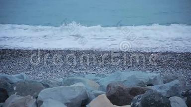 海上冲浪。 波浪在海岸卵石上流动。