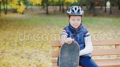 一个手臂<strong>骨折</strong>的白人男孩坐在溜冰场