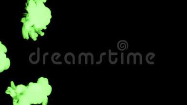 绿色墨水滴溶解在水中缓慢的运动隔离在黑色背景。 包括卢马哑光作为使用