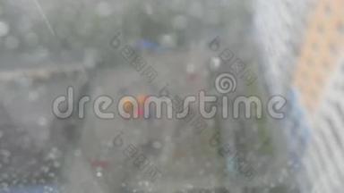 在暴风雨的一天里，城市的雨滴落在窗户上，背景下的城市天际线