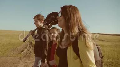 快乐家庭慢动作<strong>视频</strong>行走在大自然男孩女孩和妈妈在<strong>野外</strong>徒步旅行。 带吉他的游客
