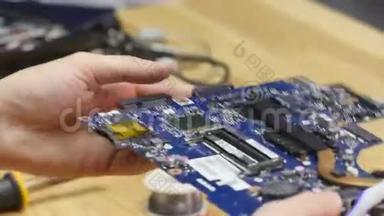 修理工拆卸笔记本电脑主板。 工程师在工作中修理坏电脑。 电子修理店，技术