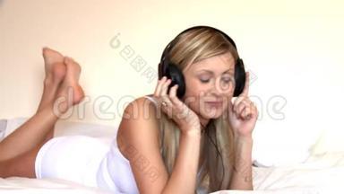 躺在床上听音乐的金发女人