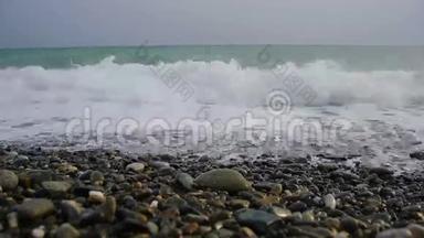 海上冲浪。 波浪在海岸卵石上流动。