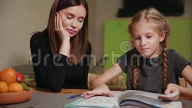 母亲和女儿做学校作业。 妈妈帮忙处理。