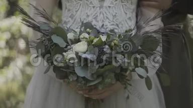 新娘穿着<strong>蕾丝连衣裙</strong>，捧着美丽的白色婚礼花束。