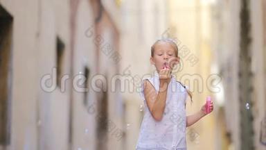 可爱<strong>的</strong>小女孩户外吹肥皂泡在欧洲城市。 白种人儿童享受<strong>暑假的</strong>肖像。