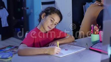 小女孩在桌子上画画。 女学生少年在室内用铅笔画画