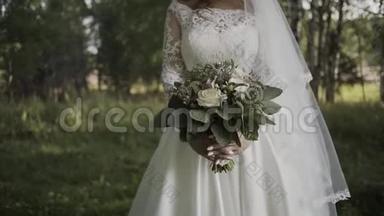 新娘穿着蕾丝连衣裙，捧着美丽的白色婚礼花束。