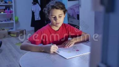 小女孩在桌子上画画。 女学生室内少年用铅笔画画