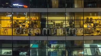 多层现代玻璃和金属办公楼中的发光窗在夜晚时光倒流时点亮。