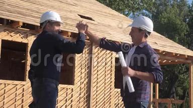 团队合作。 概念建设构建建筑师慢动作视频。 两个戴头盔的人握手契约