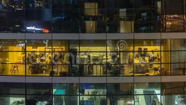 多层现代玻璃和金属<strong>办公楼</strong>中的发光窗在<strong>夜晚</strong>时光倒流时点亮。