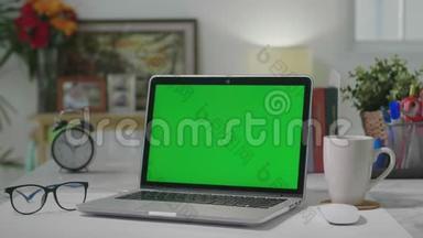 笔记本电脑绿色屏幕，家庭办公室，娃娃镜头。 Chroma键式笔记本电脑