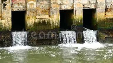 日常生活视频雨后.. 城市里一条运河里的水正在流向大海. 排水及防止水浸