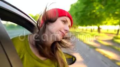 阳光明媚的一天，幸福的年轻女子坐在副驾驶座上<strong>看</strong>着<strong>窗外</strong>