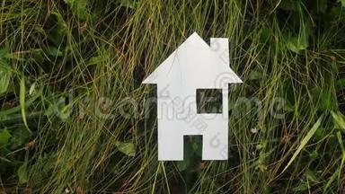 生活方式幸福家庭建设之家理念.. 纸屋矗立在大自然的绿草中。 象征生命生态