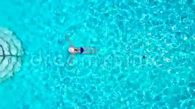 从顶部看，一个穿<strong>蓝色</strong>泳衣的女人在游<strong>泳池里</strong>游泳