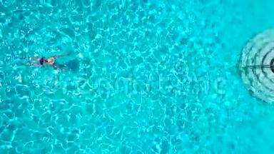 从顶部看，一个穿<strong>蓝色</strong>泳衣的女人在游<strong>泳池里</strong>游泳
