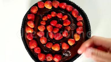 把新鲜的草莓放在装饰蛋糕上，配上巧克力。