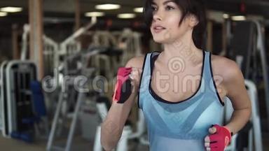 在健身房跑步<strong>机</strong>上跑步的女孩。 做有氧运动的年轻女人。 在健身房锻炼，跑步<strong>机</strong>