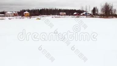 冬天，在雪覆盖的湖面上，汽车在结冰的轨道上行驶。 空中观景。 冬季雪地赛道上的赛车