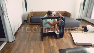 一个年轻人<strong>在</strong>他家的客厅里<strong>独</strong>立收集家具。一个男人收集一张电脑桌。