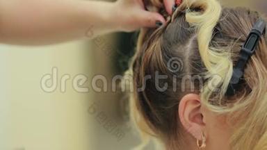 理发师在美容院做发型。 美容院的年轻女子