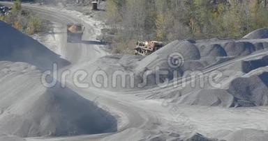 一辆黄色装载的自卸卡车在采石场里，一个采石场里的工作过程，一个采石场里的一辆黄色自卸卡车