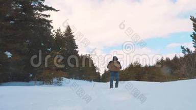 人的脚在深雪中行走。 慢动作视频。 带背包的人在雪林冬天散步。 克服困难