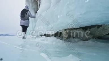 贝加尔湖冰上女子<strong>旅行</strong>。 <strong>去</strong>冬岛<strong>旅行</strong>。 女孩走在冰岩脚下。 <strong>旅行</strong>者看着