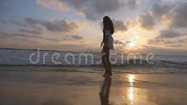 年轻漂亮的女孩在海边享受生活和乐趣。 快乐的女人在海滩上散步和玩耍