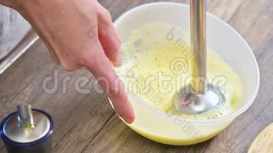 将自制蛋黄酱用搅拌机在塑料碗中搅拌