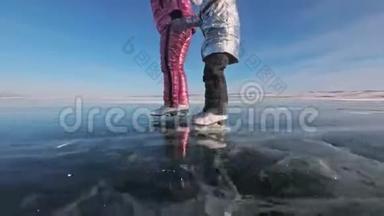 家人白天在滑冰。 女孩们骑着大自然中的花样冰鞋。 妈妈和女儿一起骑在冰上