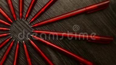 许多红色的钢笔在<strong>黑色</strong>的木制背景上围成一个圆圈。 概念办或学校，知识日，<strong>九月</strong>一日..
