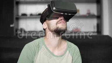 年轻留胡子的嬉皮士用他的VR耳机显示虚拟现实游戏或观看360视频坐着