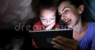 母亲和女儿在家使用数码平板电脑