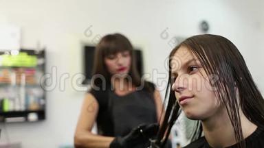 理发店的一位年轻女士被女理发师理发