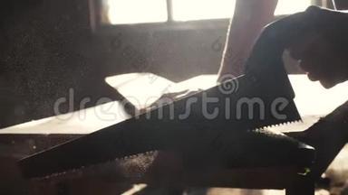 人木匠手工制作和工艺概念慢动作视频.. 木工在车间里锯树，从一个车间里锯阳光